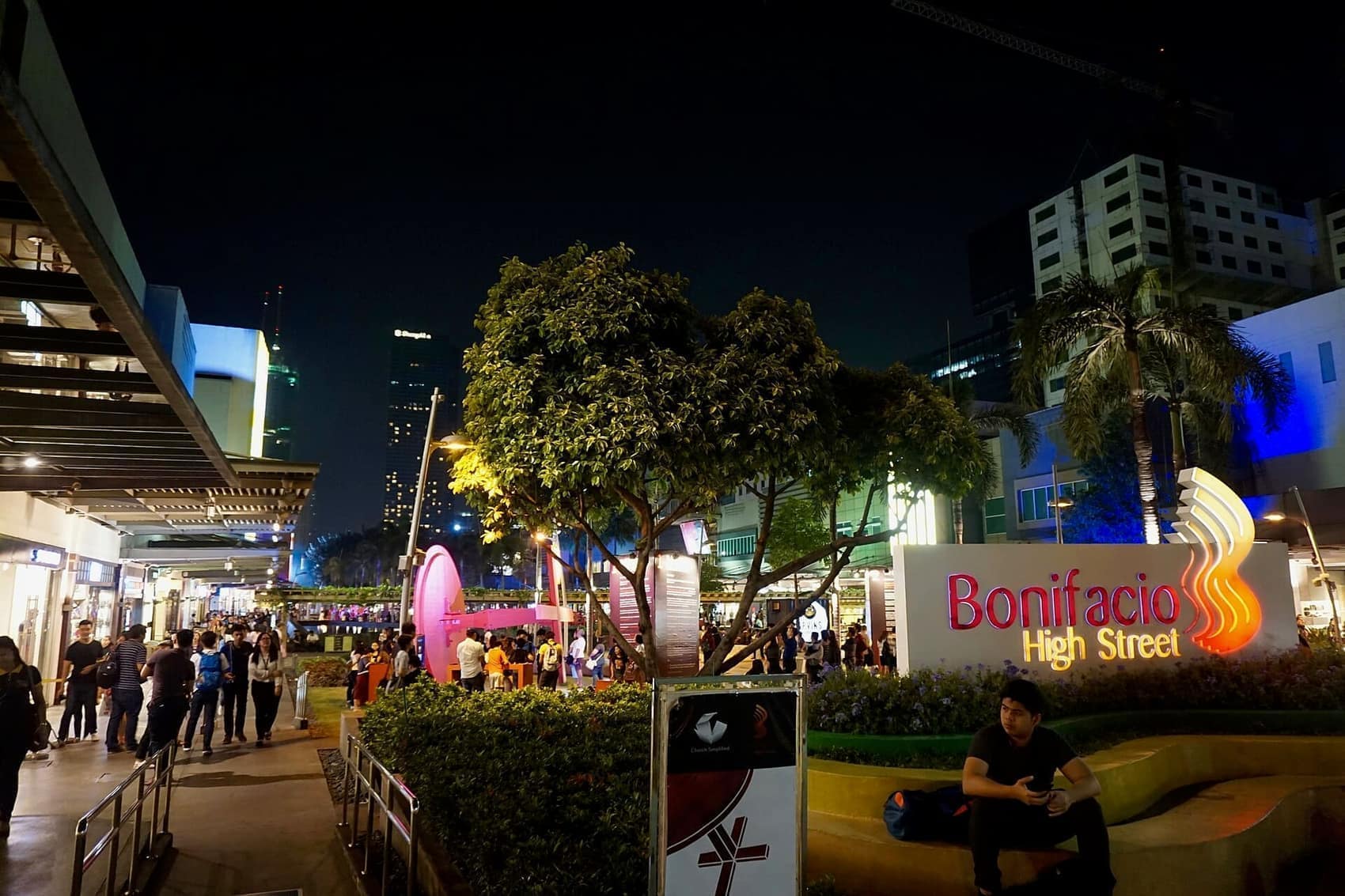 High Street after dark: installations lit up, shops still open