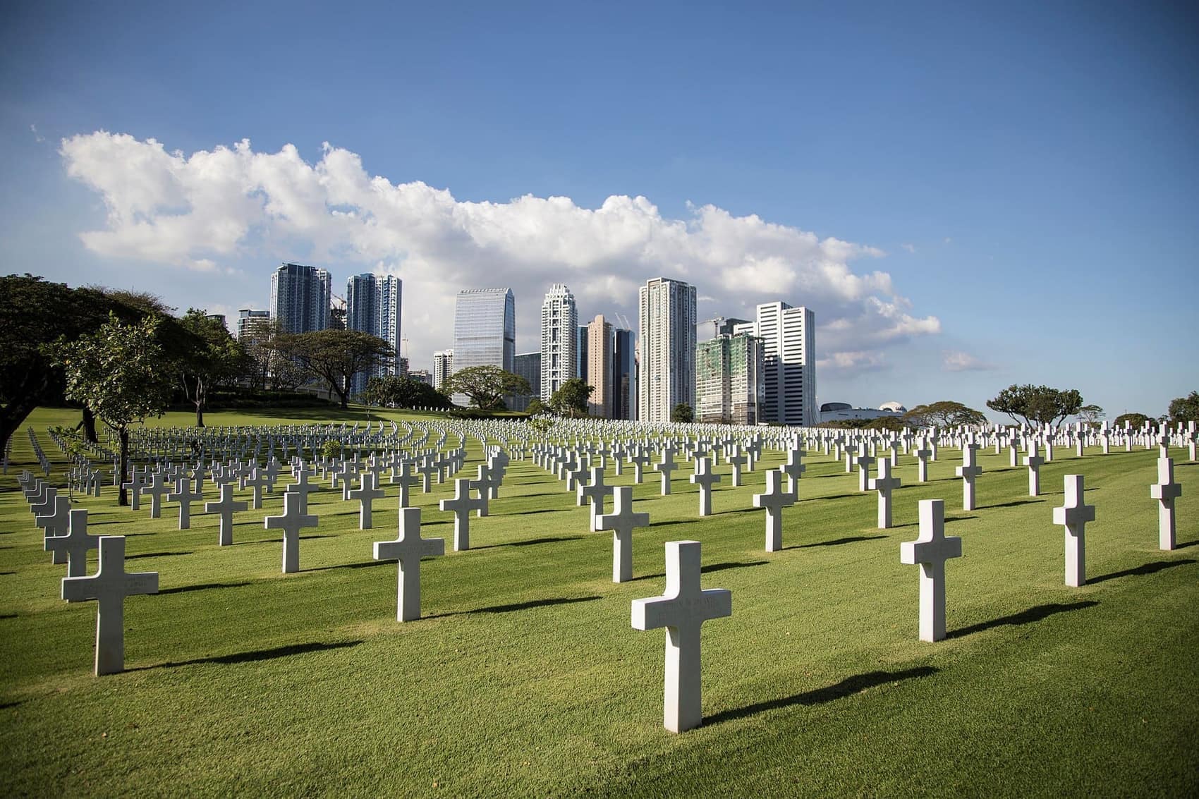 Manila American Cemetery: rows of marble crosses with the BGC skyline behind them