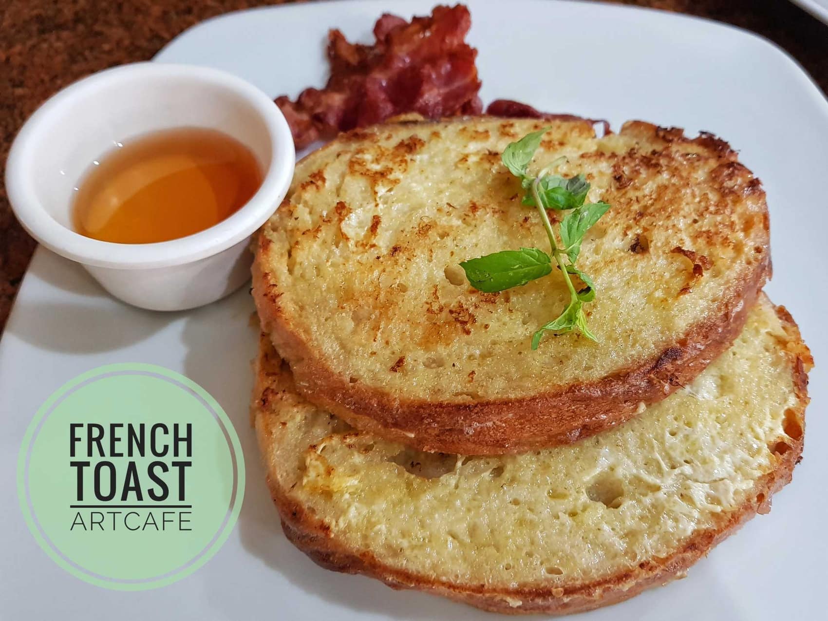 French toast cut from their own bread, served with a jug of syrup and bacon