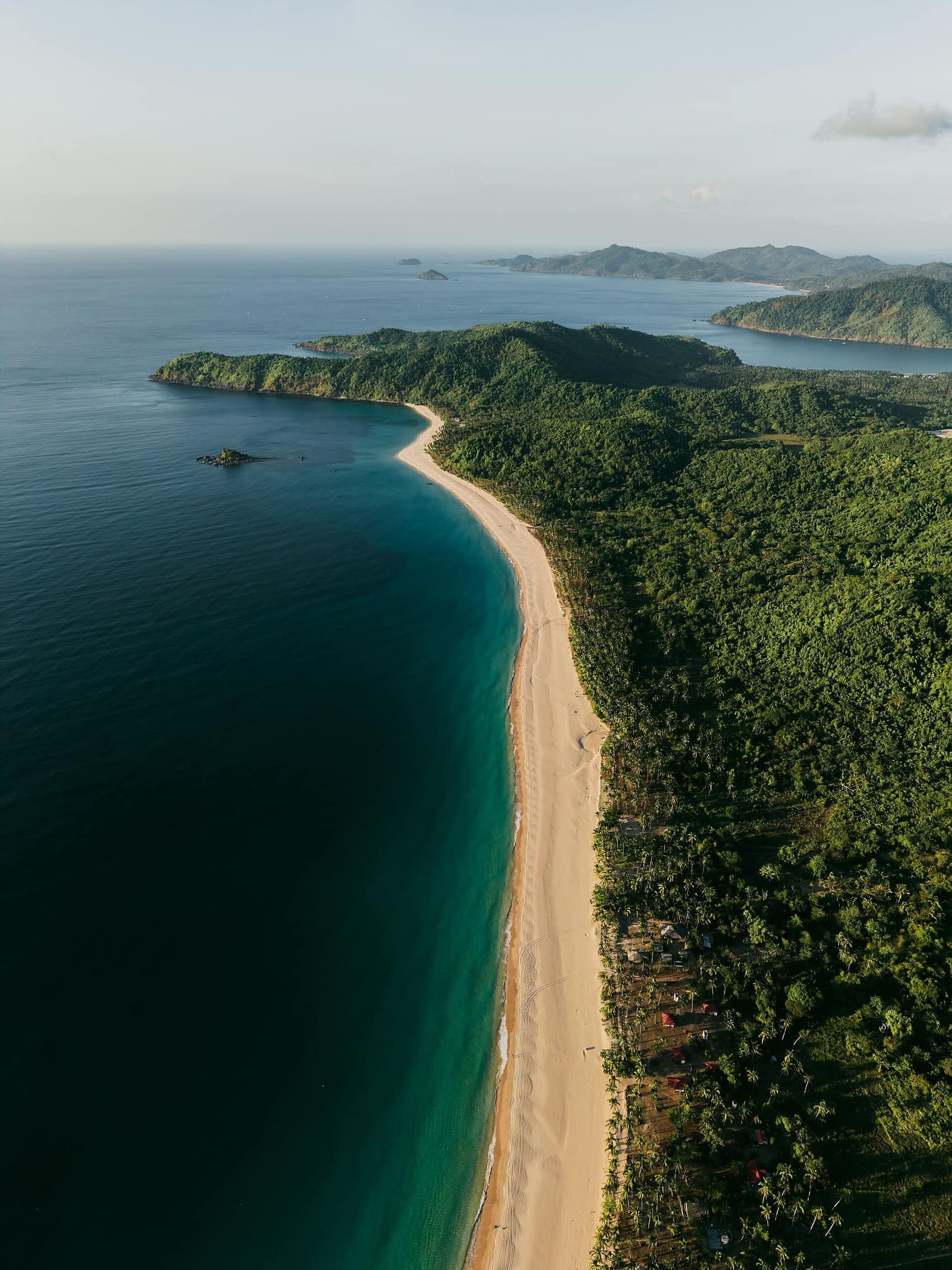 The long curve of Nacpan meeting the jungle, seen from above