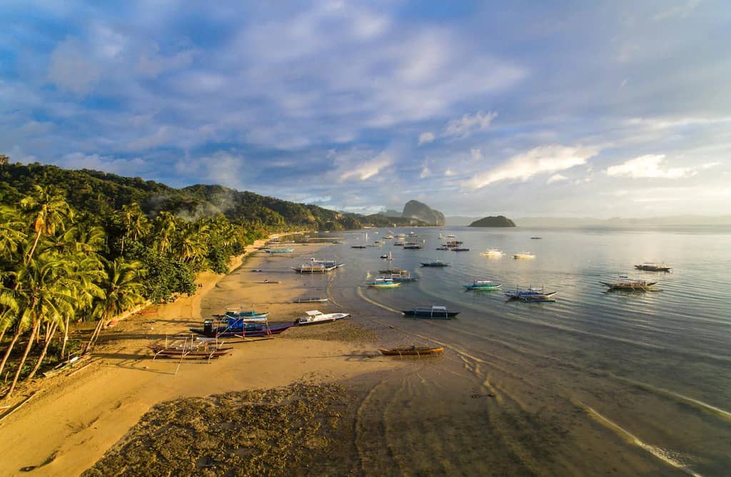 The Las Cabanas / Corong-Corong beach strip at first light, boats lined up on the sand