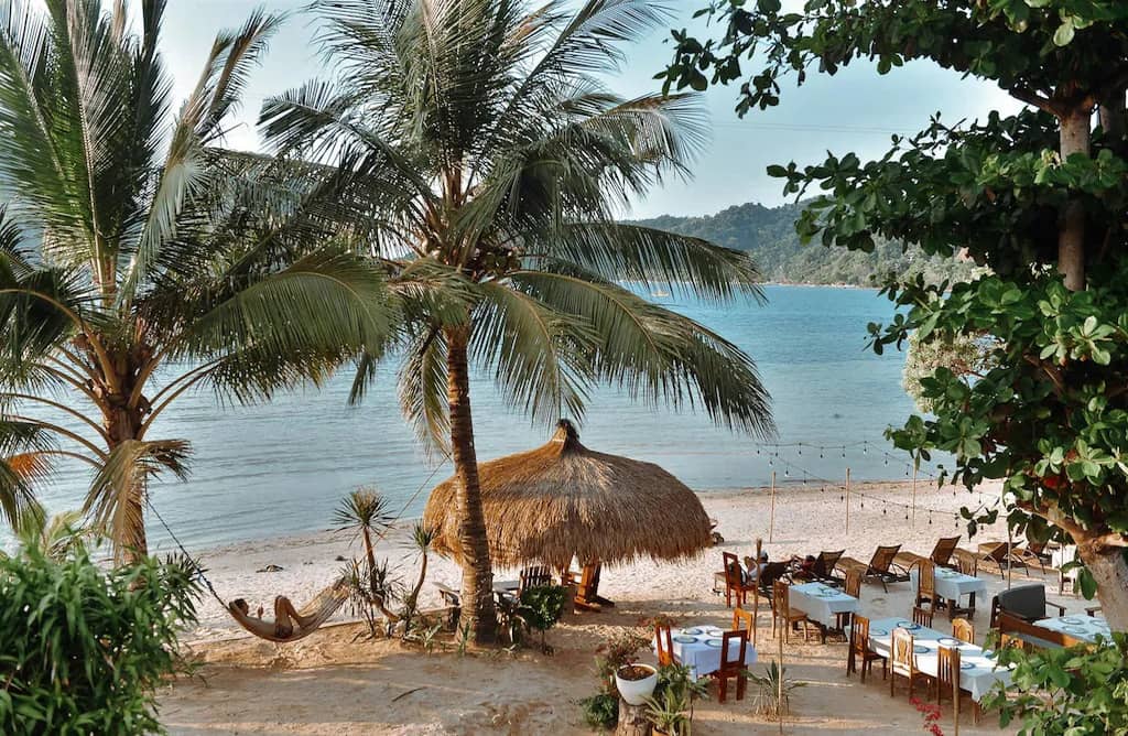Thatched shade and palms on Las Cabanas Beach, the west-facing sunset strip
