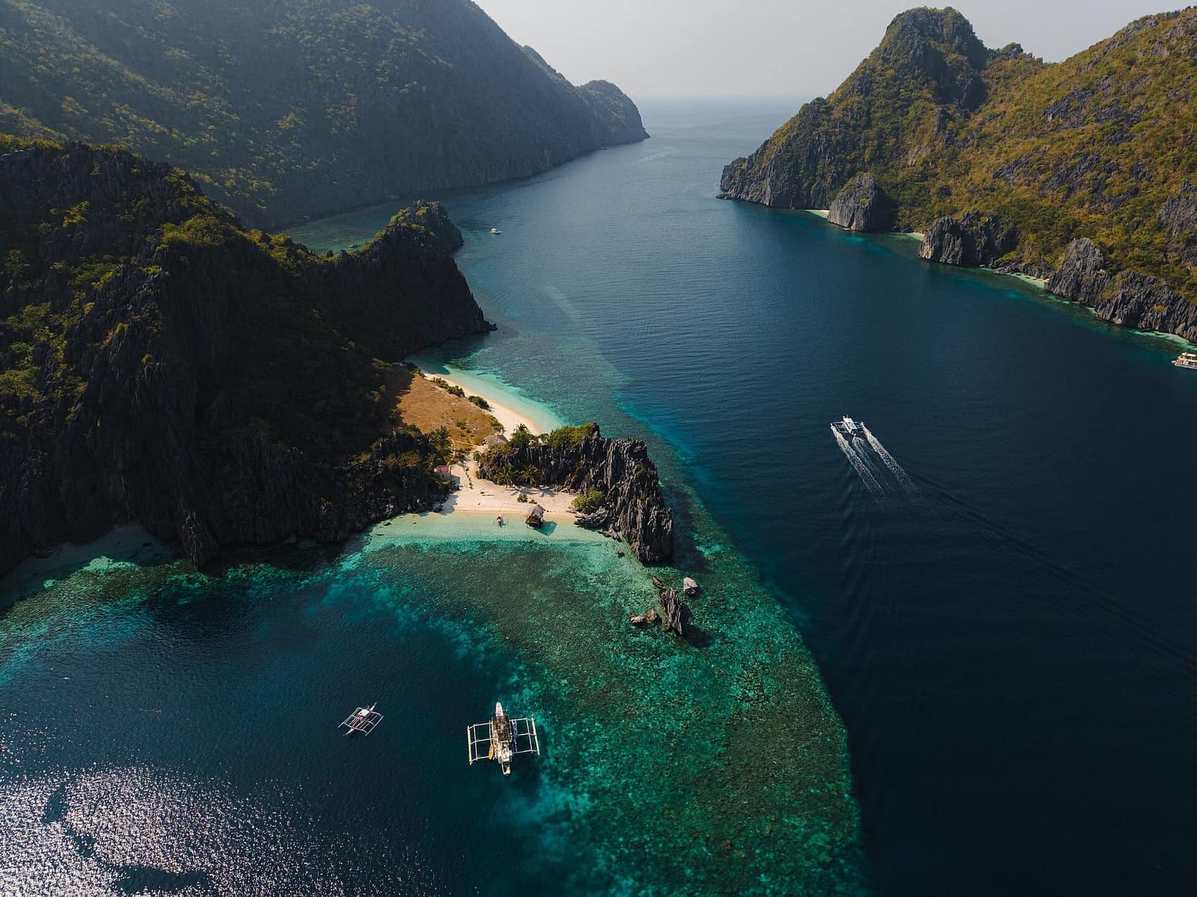 Aerial over the channel at Tapiutan, boats threading between two limestone walls