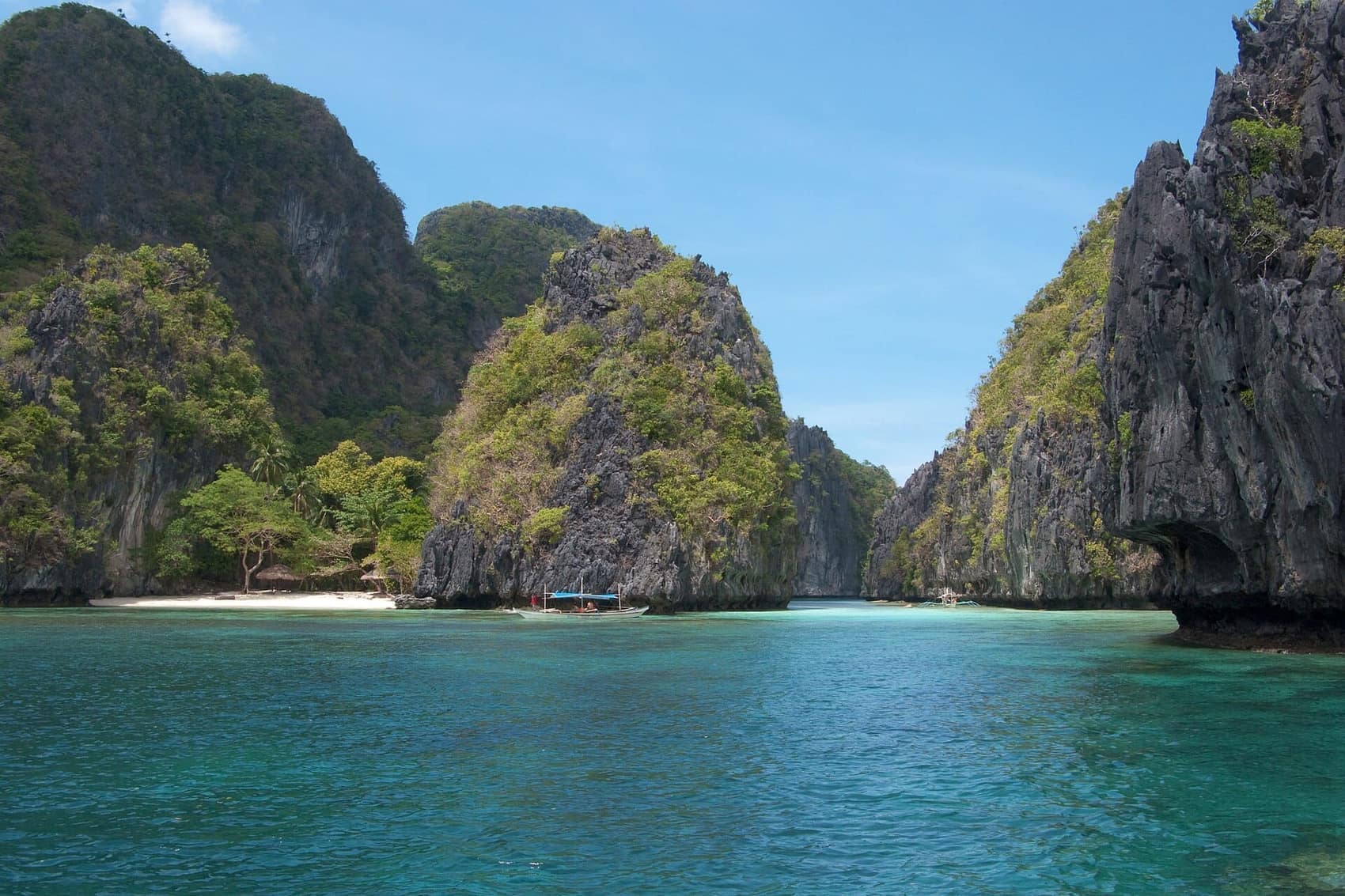 A sliver of white sand at the base of a limestone cliff, Bacuit Bay