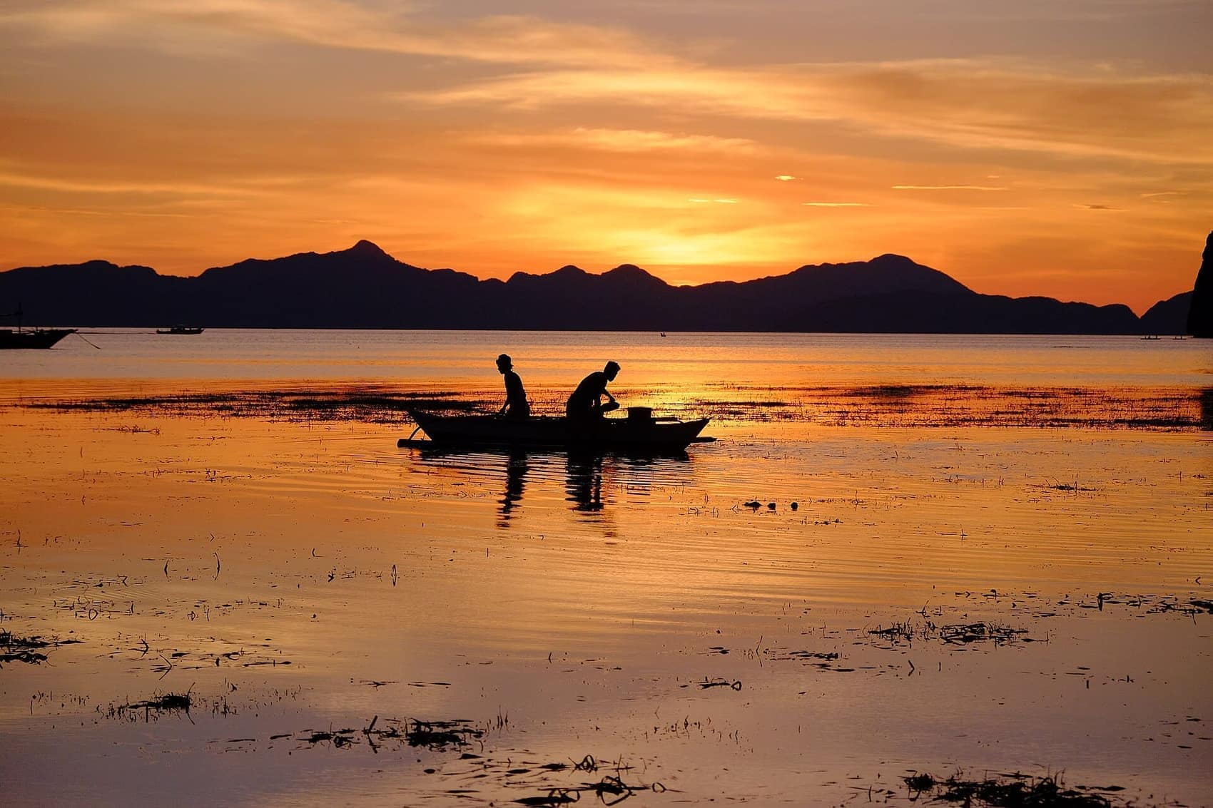 Fishermen heading home after sunset. The boats come back in silhouette every evening