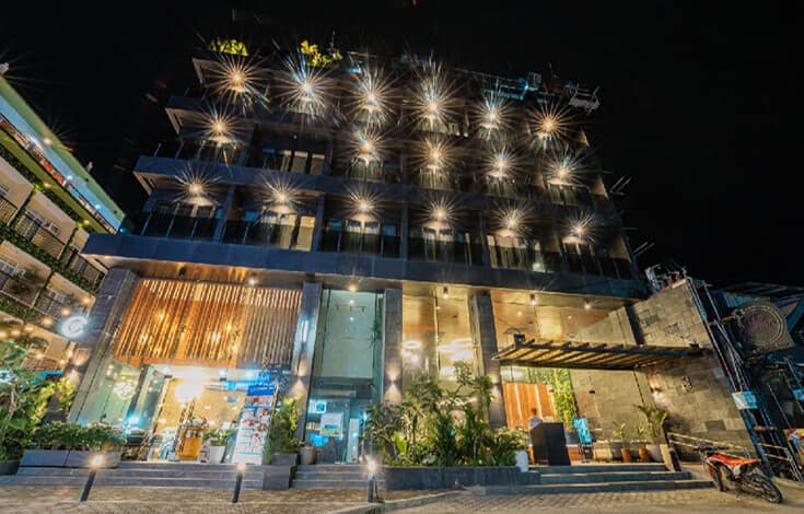The facade lit up after dark on the downtown grid