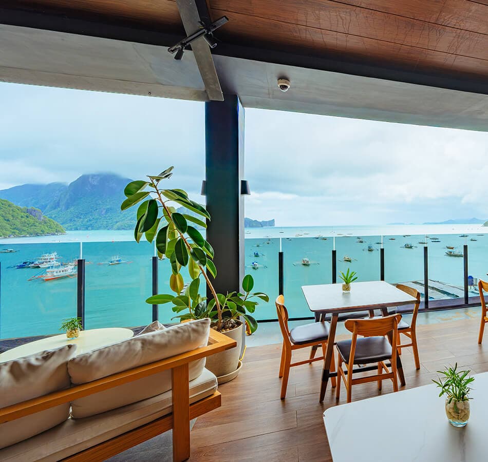 Rooftop sofas and low tables facing the harbour and the outrigger fleet