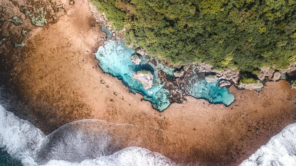 Magpupungko from the air at low tide: turquoise pools stranded on a bare reef shelf
