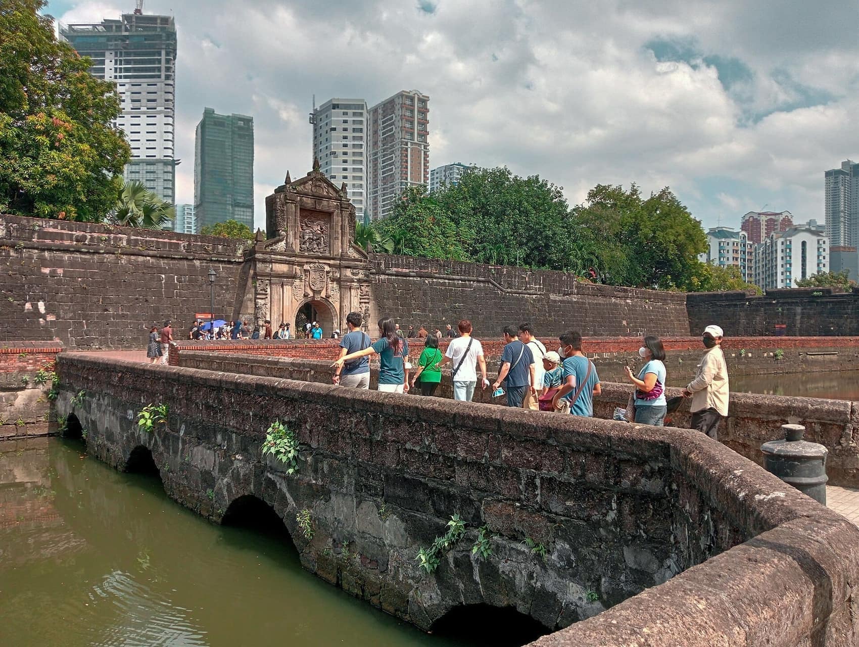 Visitors crossing the moat bridge into the fort