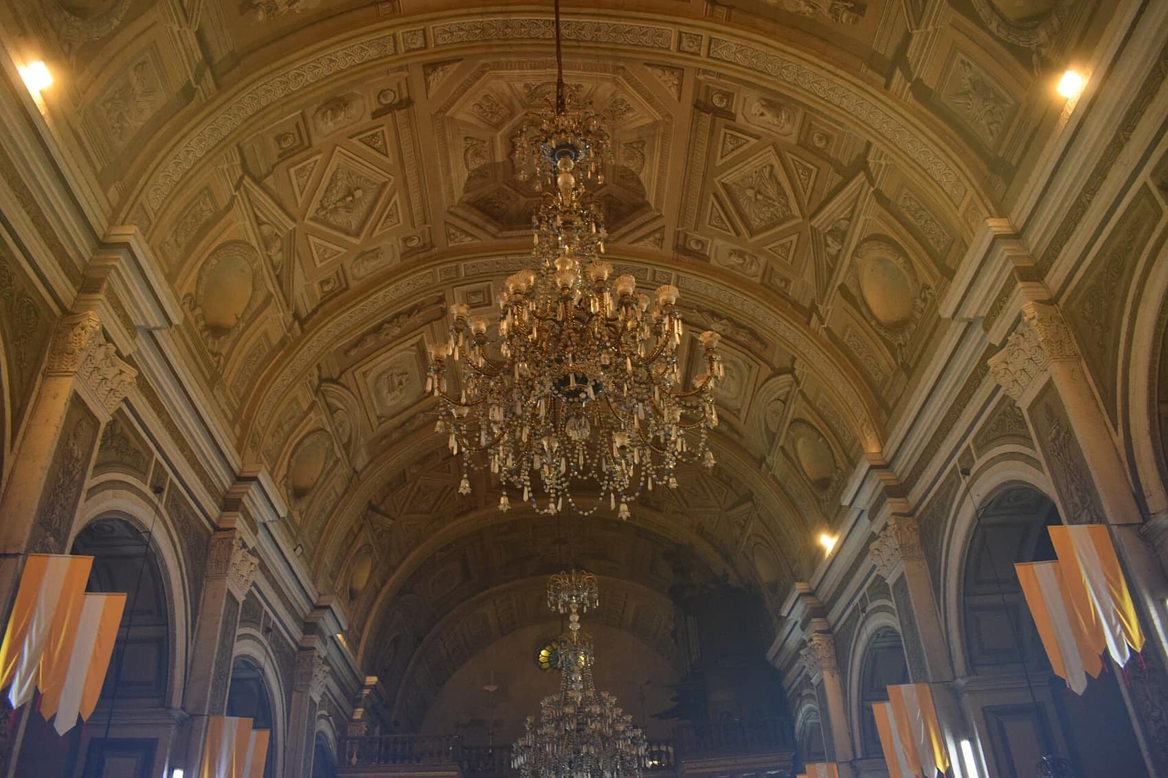 San Agustin Church: chandeliers under a ceiling painted to look carved