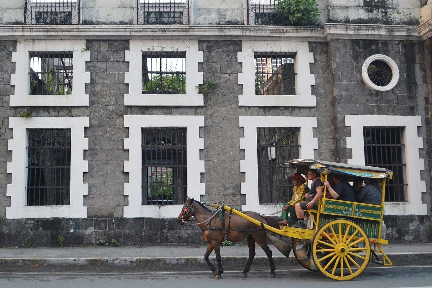 A kalesa passing the Aduana ruins on an Intramuros back street