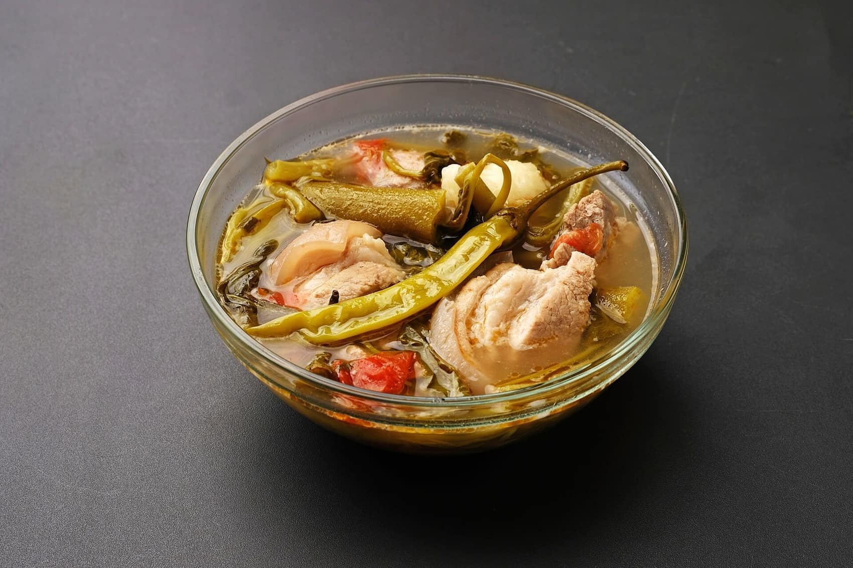 Sinigang na baboy: pork in tamarind broth with long chillies and kangkong