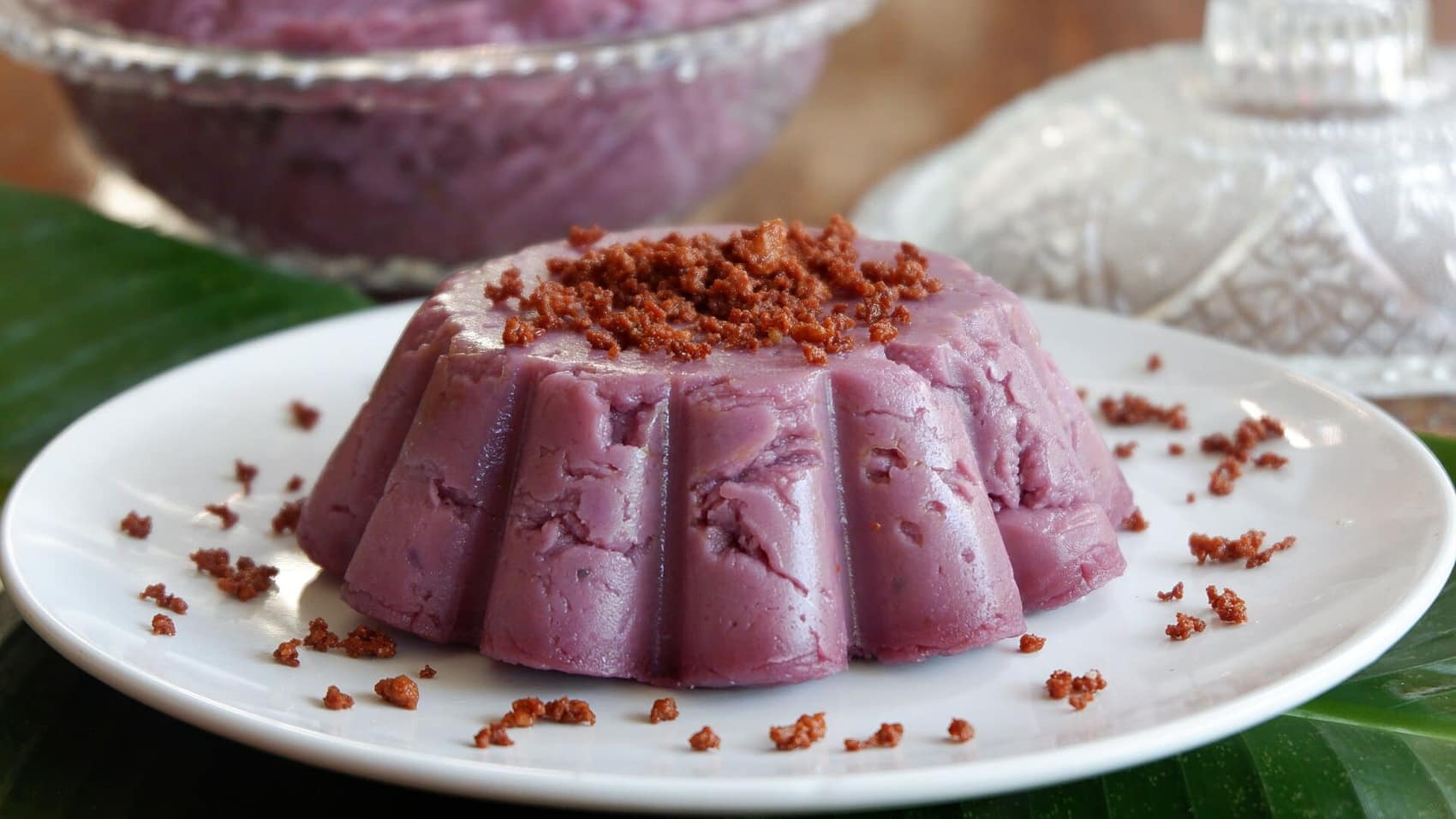 Ube halaya turned out of its mould with latik crumbs