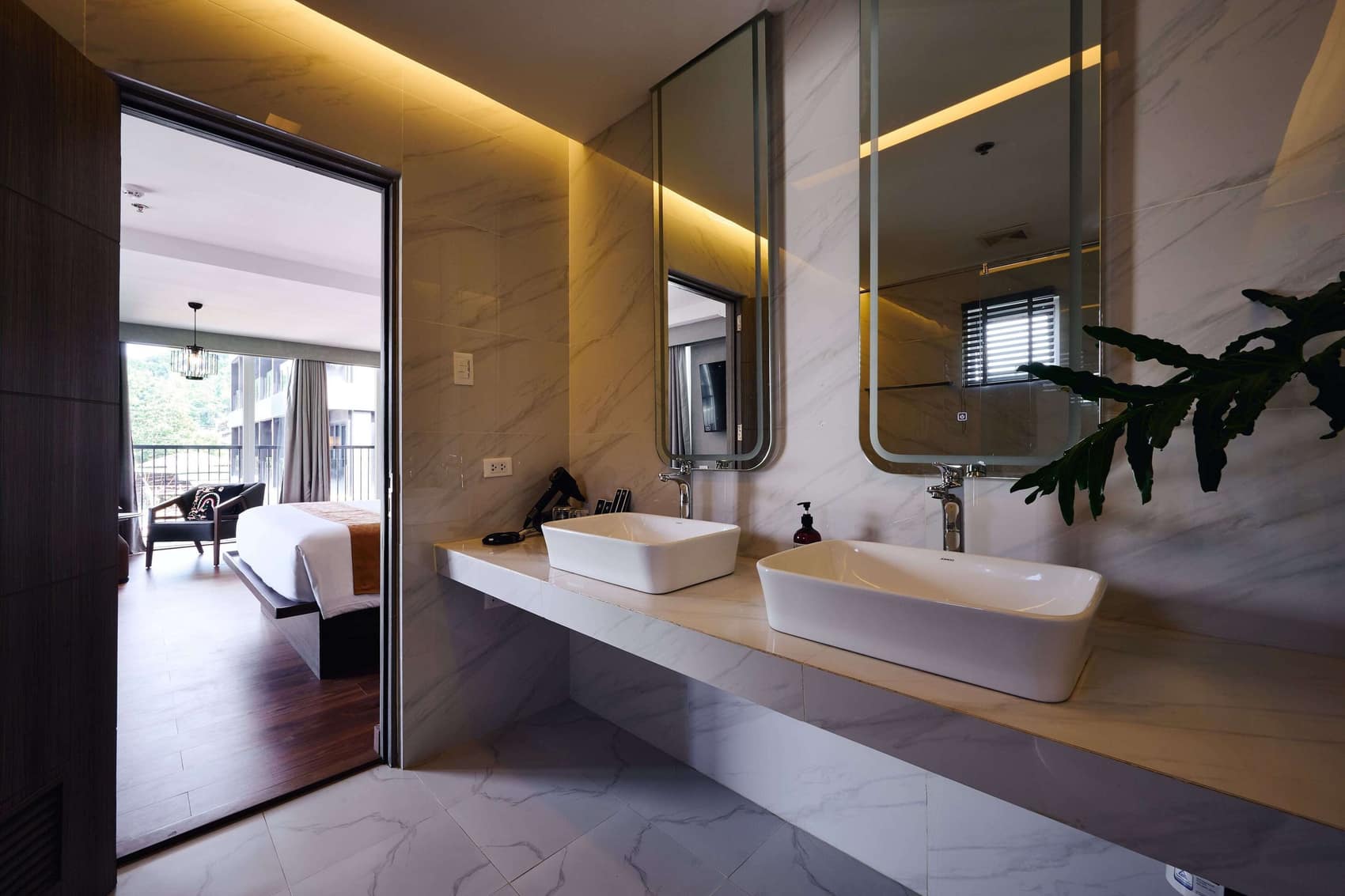 Double-vanity marble bathroom opening onto a balcony