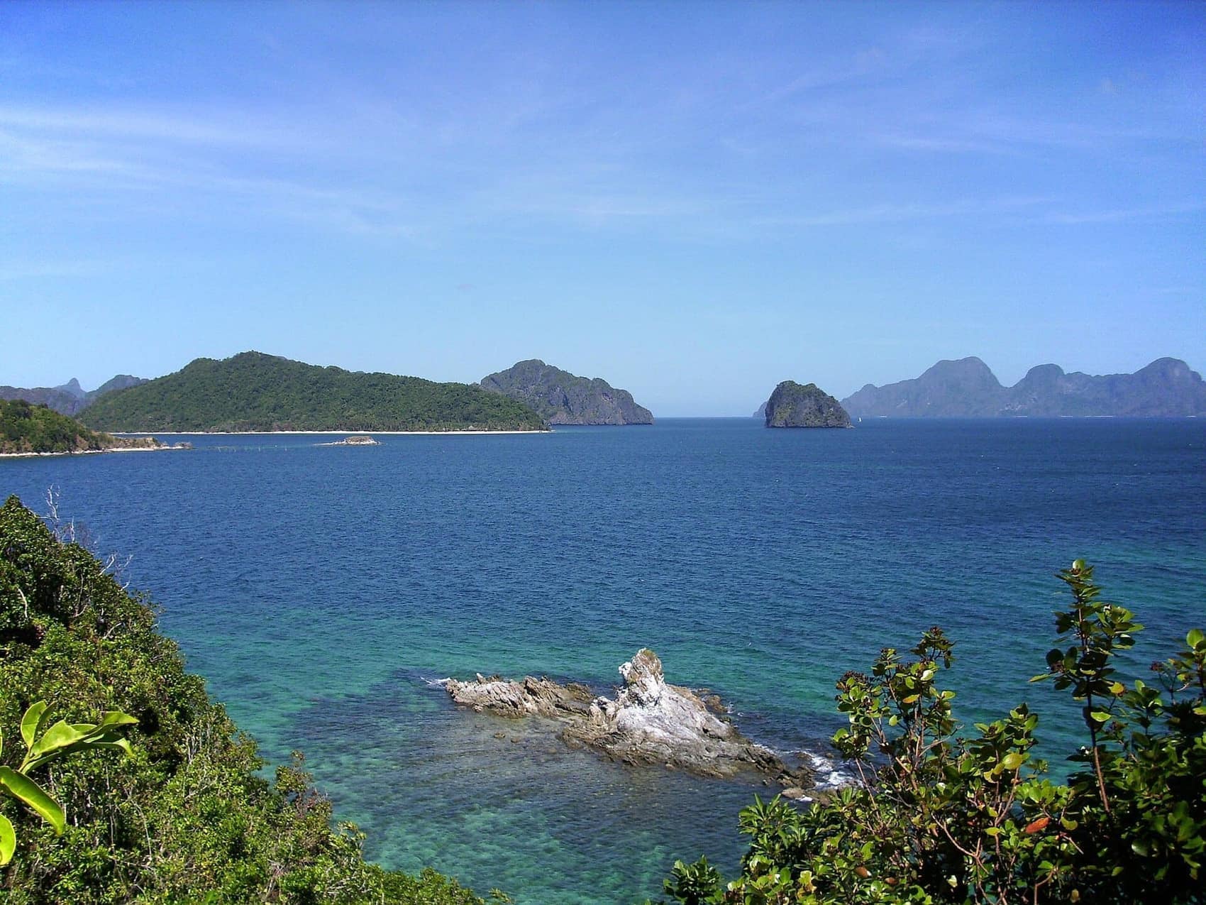 Bacuit Bay from the water: jungle-topped karst towers dropping straight into turquoise